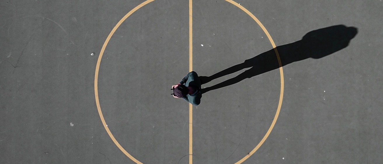 A person standing in the center of a basketball court