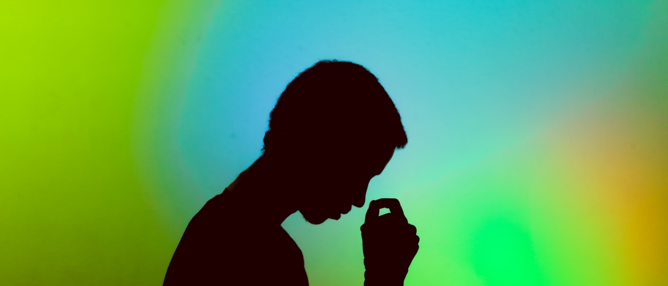 A silhouette of a person in front of a green background
