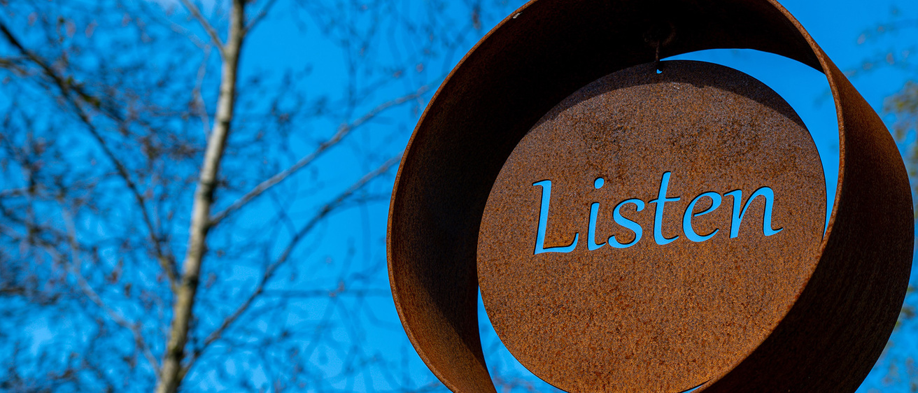 Image of a sculpture showing the word "Listen"