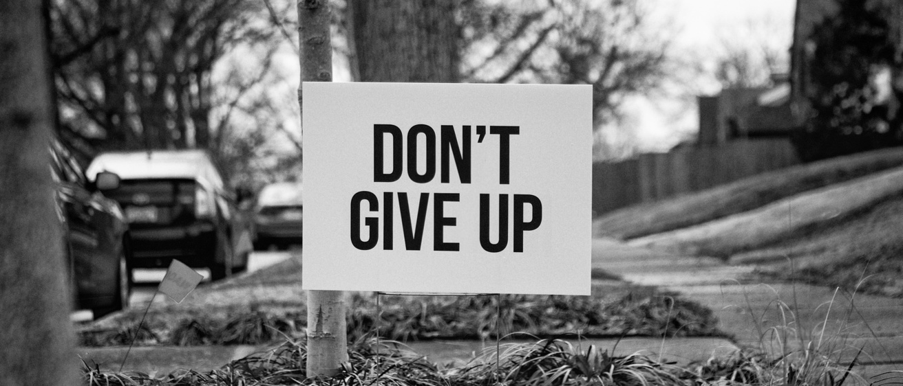 image of a street and text that reads "don't give up"