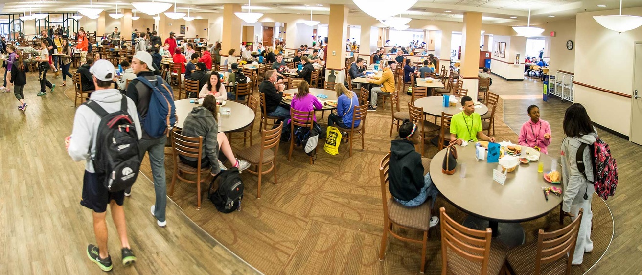 Burge dining hall with many people eating and talking