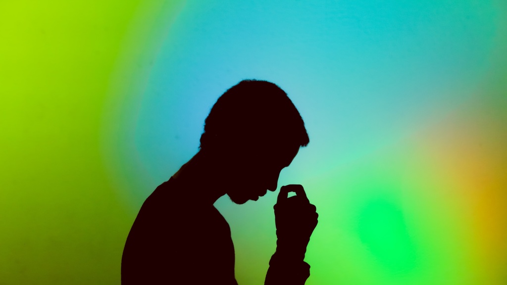 A silhouette of a person in front of a green background